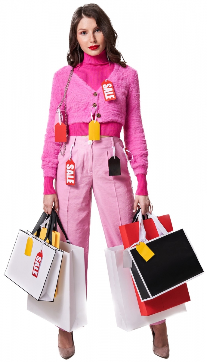 Chica posando con bolsas de compras en el estudio