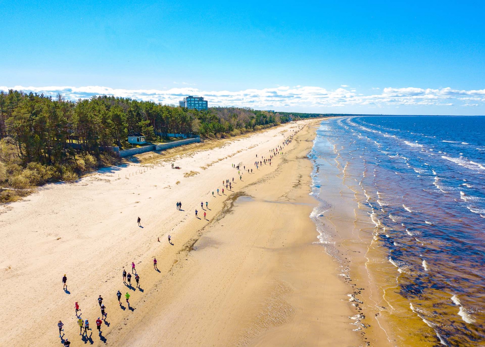 Vista aerea dal drone sulla folla di persone che stanno iniziando a correre durante la maratona in riva al mare a Jurmala, in Lettonia