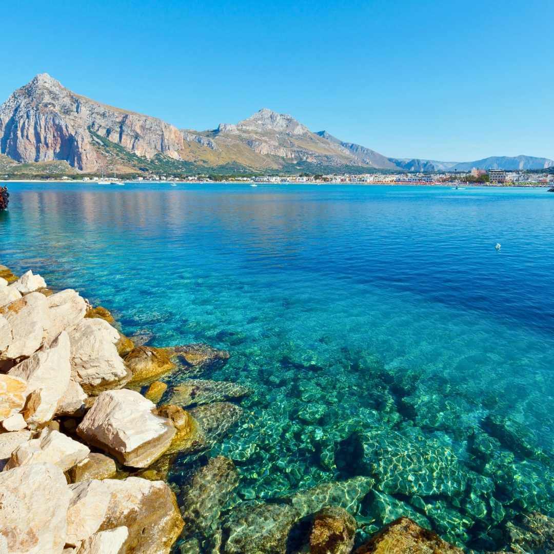 Spiaggia di San Vito lo Capo con acque azzurre e limpide e Monte Monaco nell'estrema Sicilia nord-occidentale, Italia.