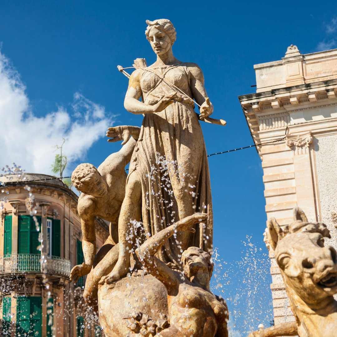 La Fontana Diana fu costruita nel 1907 e gli edifici circostanti si trovano in Piazza Archimede, al centro dell'isola di Ortigia a Siracusa, in Sicilia, Italia.