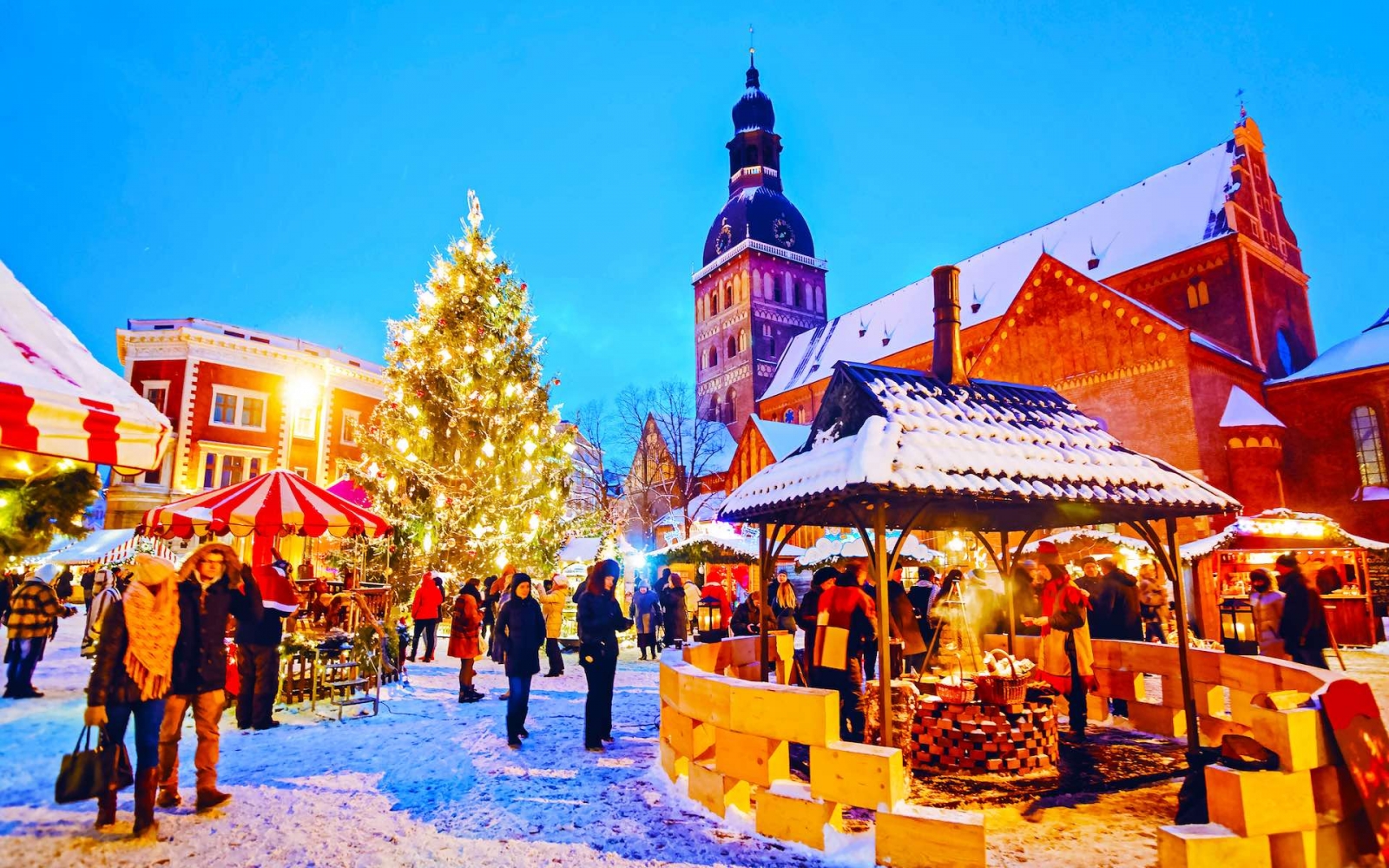 Nächtliches Stadtbild mit Weihnachtsmarkt am Domplatz im Winter Riga, Lettland.  Adventsmarktdekoration und Stände mit Kunsthandwerk
