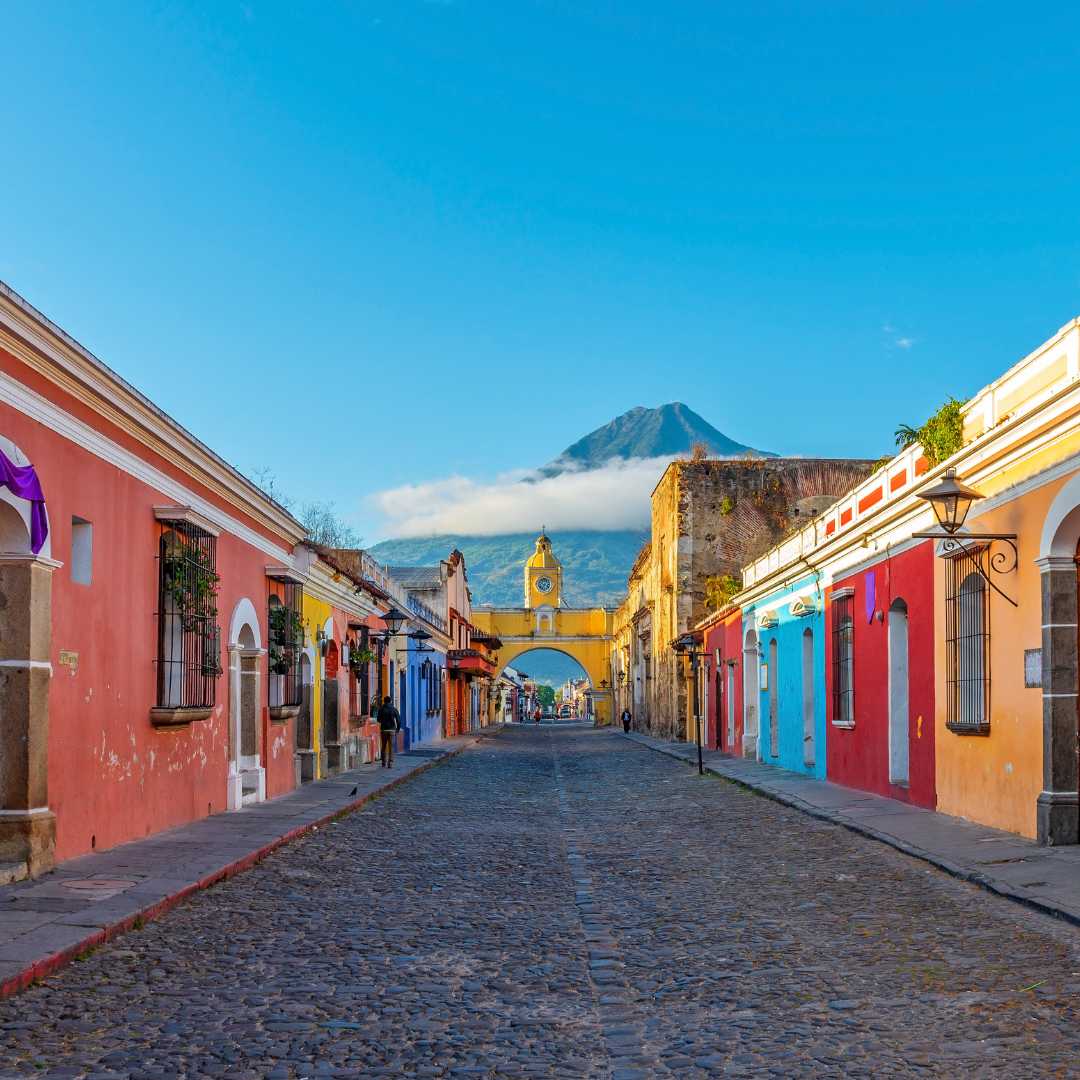 Paisaje urbano de la ciudad de Antigua al amanecer con el arco de Santa Catalina y el volcán Agua con espacio para copiar, Guatemala