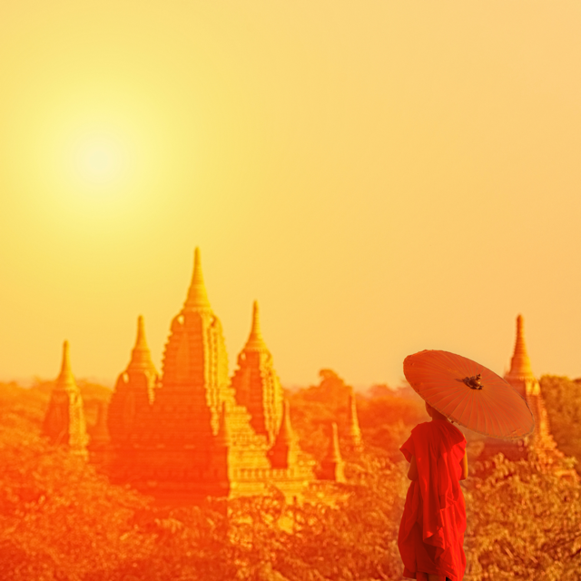 Monaco in piedi con ombrello in mano a Mandalay, Myanmar