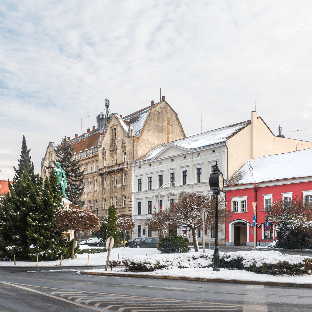 Paisaje urbano invernal del casco antiguo de Sopron: Plaza Szechenyi, la estatua de Istvan Szechenyi, la Iglesia Dominicana y el Palacio de Correos cubiertos de nieve