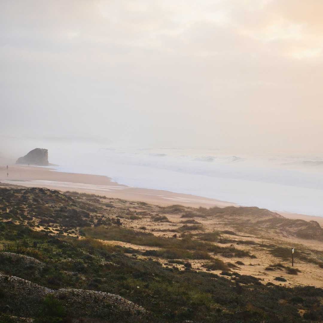 Große Wellen an der Küste, Praia do Meco, Sesimbra, Portugal. Nebliges Wetter
