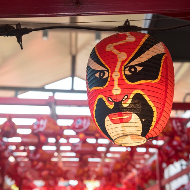 Japanische lächelnde Kabuki-Noh-Maskenlampen hängen an roten Torii-Toren