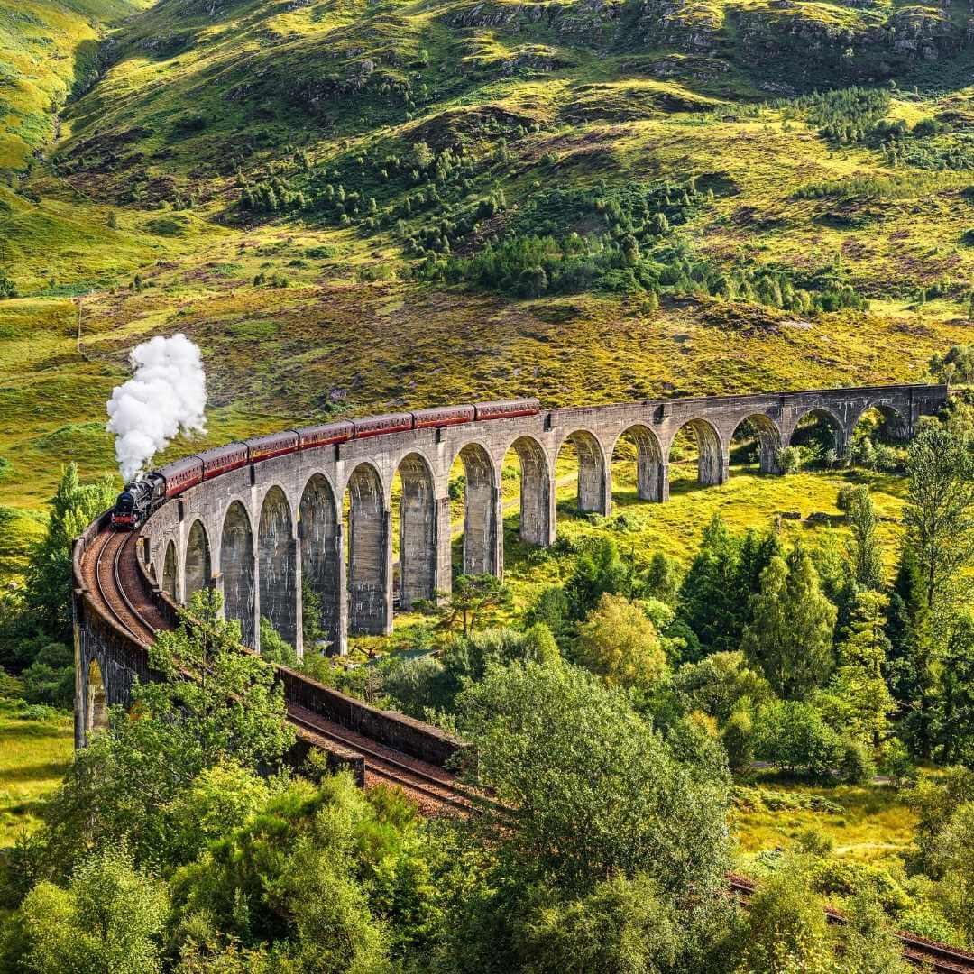 Viaduc ferroviaire de Glenfinnan en Écosse avec le train à vapeur Jacobite passant au-dessus