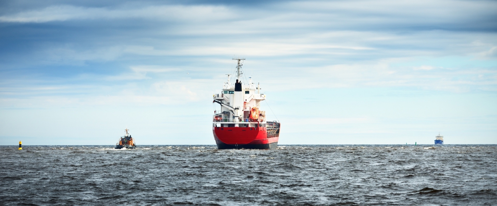 Stückgutschiff neben einem Schlepper in der offenen Ostsee.  Klaipeda, Litauen.  Wasserfahrzeuge, Gütertransport, globale Kommunikation, Industrie, Handel.