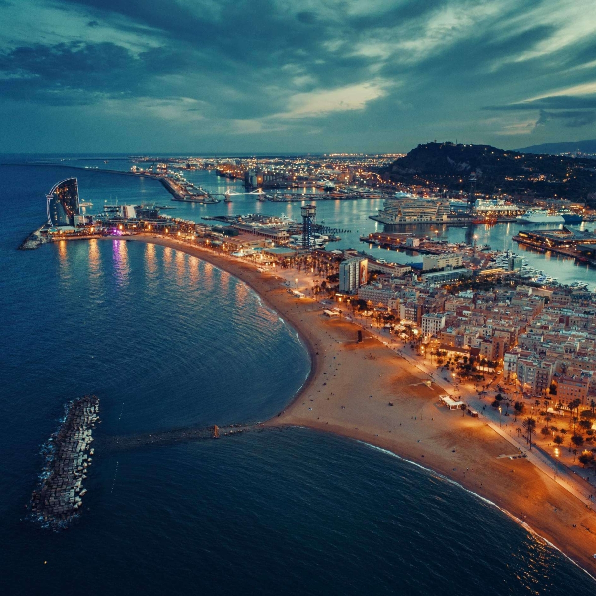 Luftaufnahme des Küstenpiers von Barcelona bei Nacht in Spanien