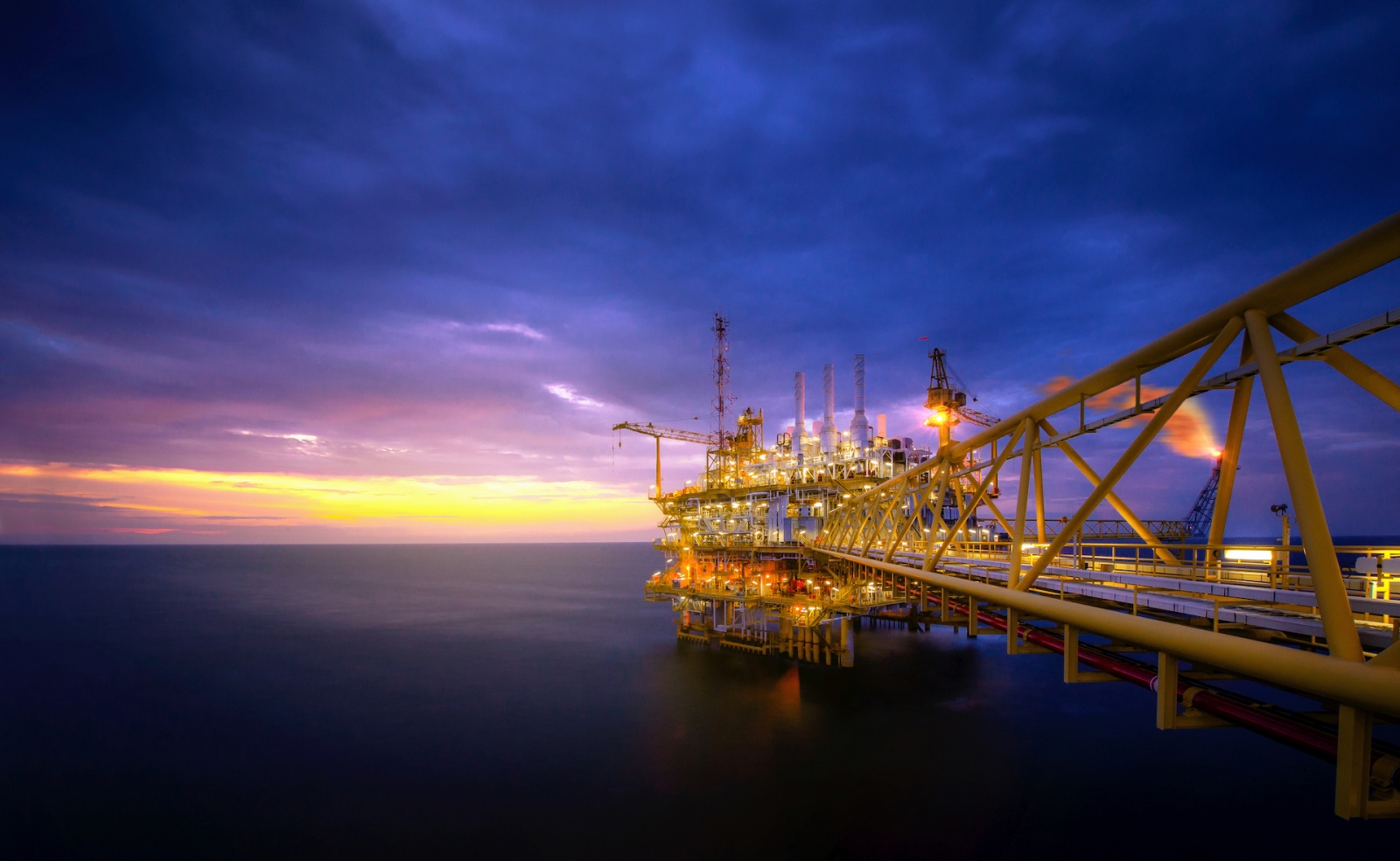 Промышленность морской нефтяной буровой установки в заливе после захода солнца
