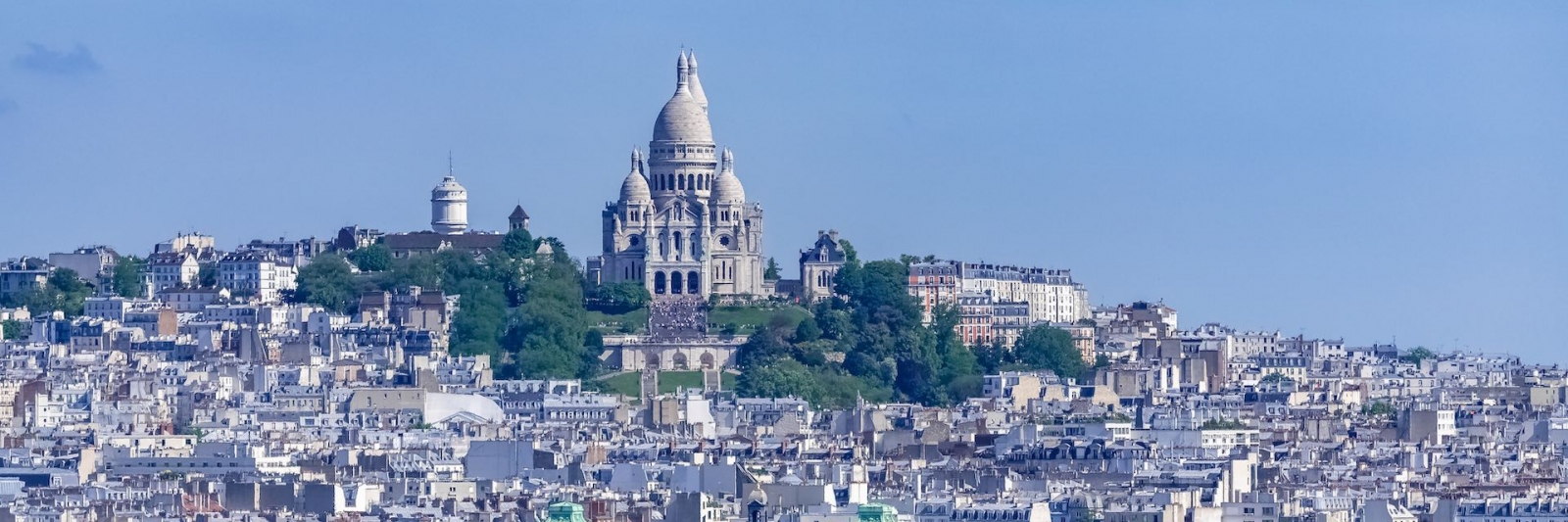 Parigi, panorama della città, tetti ed edifici tipici, con Montmartre e la basilica del Sacro Choeur sullo sfondo