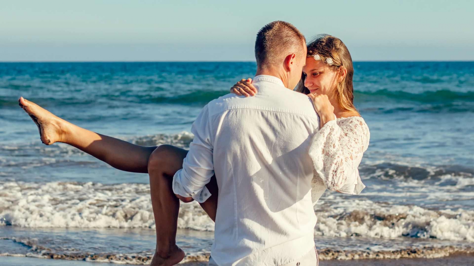 Una pareja joven en un paseo romántico por la playa de Jurmala en Letonia