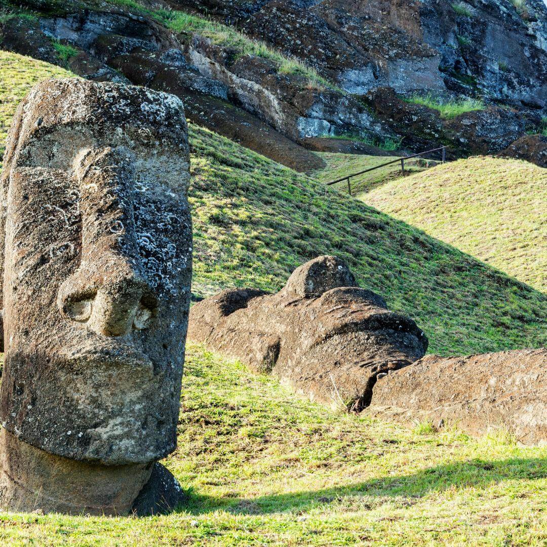 Eine stehende Moai-Statue neben einer liegenden in Rano Raraku auf der Osterinsel