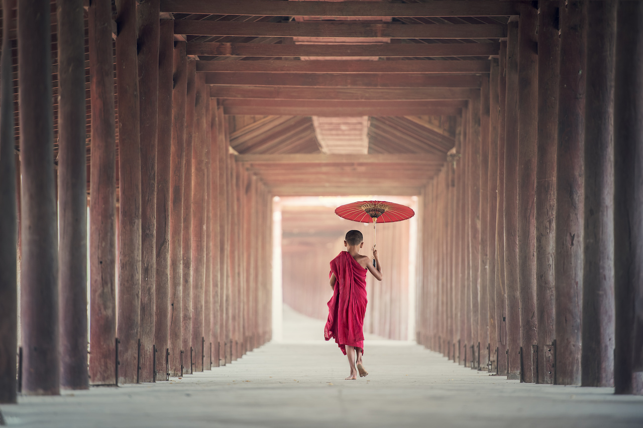 Giovane monaco buddista con ombrello in Birmania
