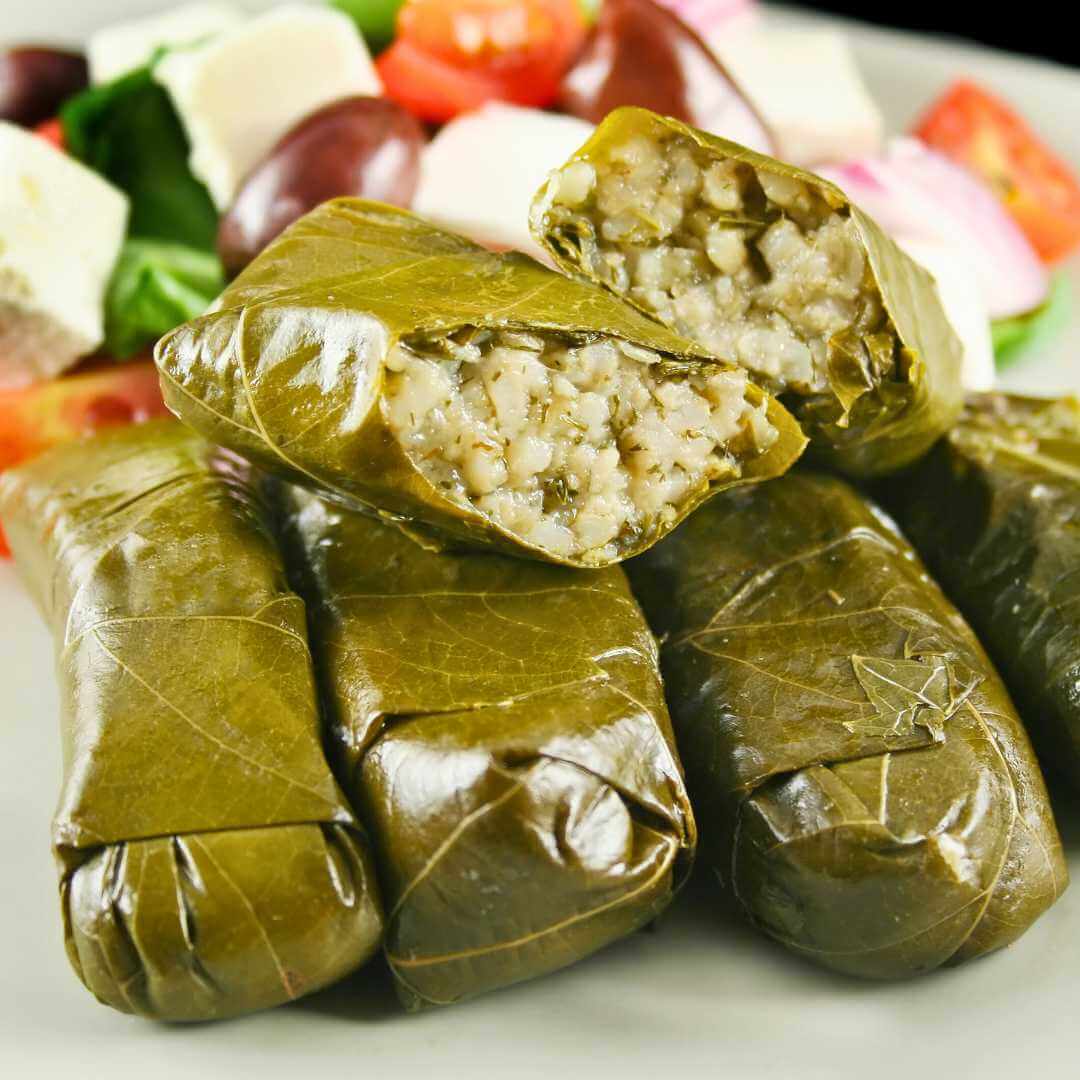 Dolmades greci avvolti in foglie di vite e riso con insalata