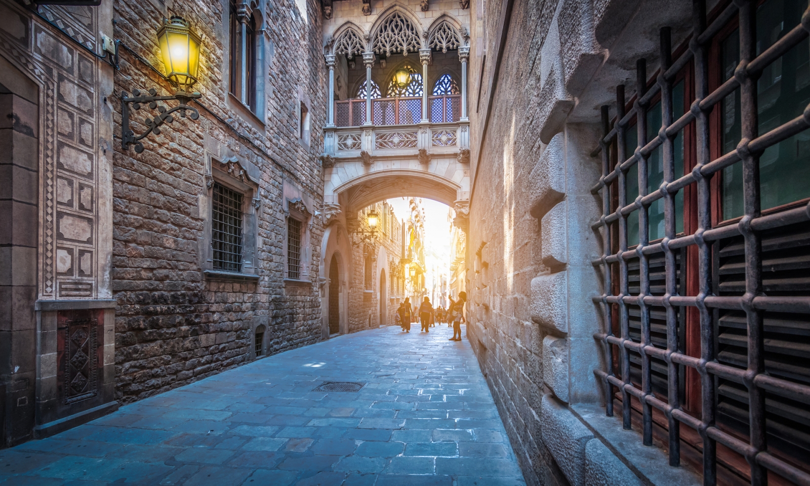 Calle estrecha con puente popular en el Barrio Gótico al anochecer, Barcelona España.