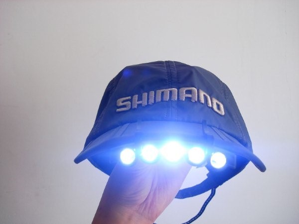 La casquette avec la lampe délibère les deux mains