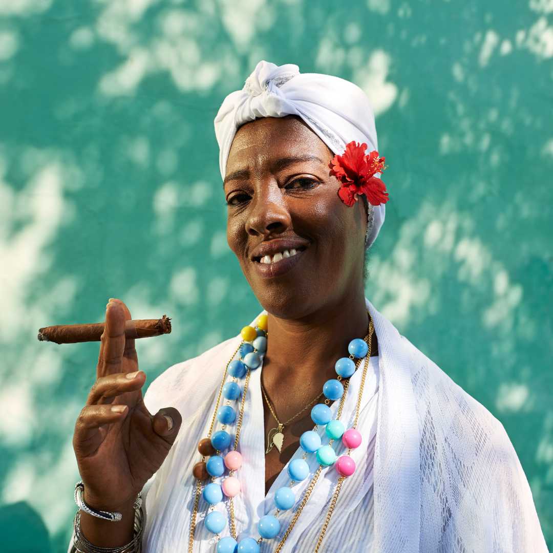 Retrato de mujer cubana fumando cigarro Cohiba y mirando a la cámara sonriendo