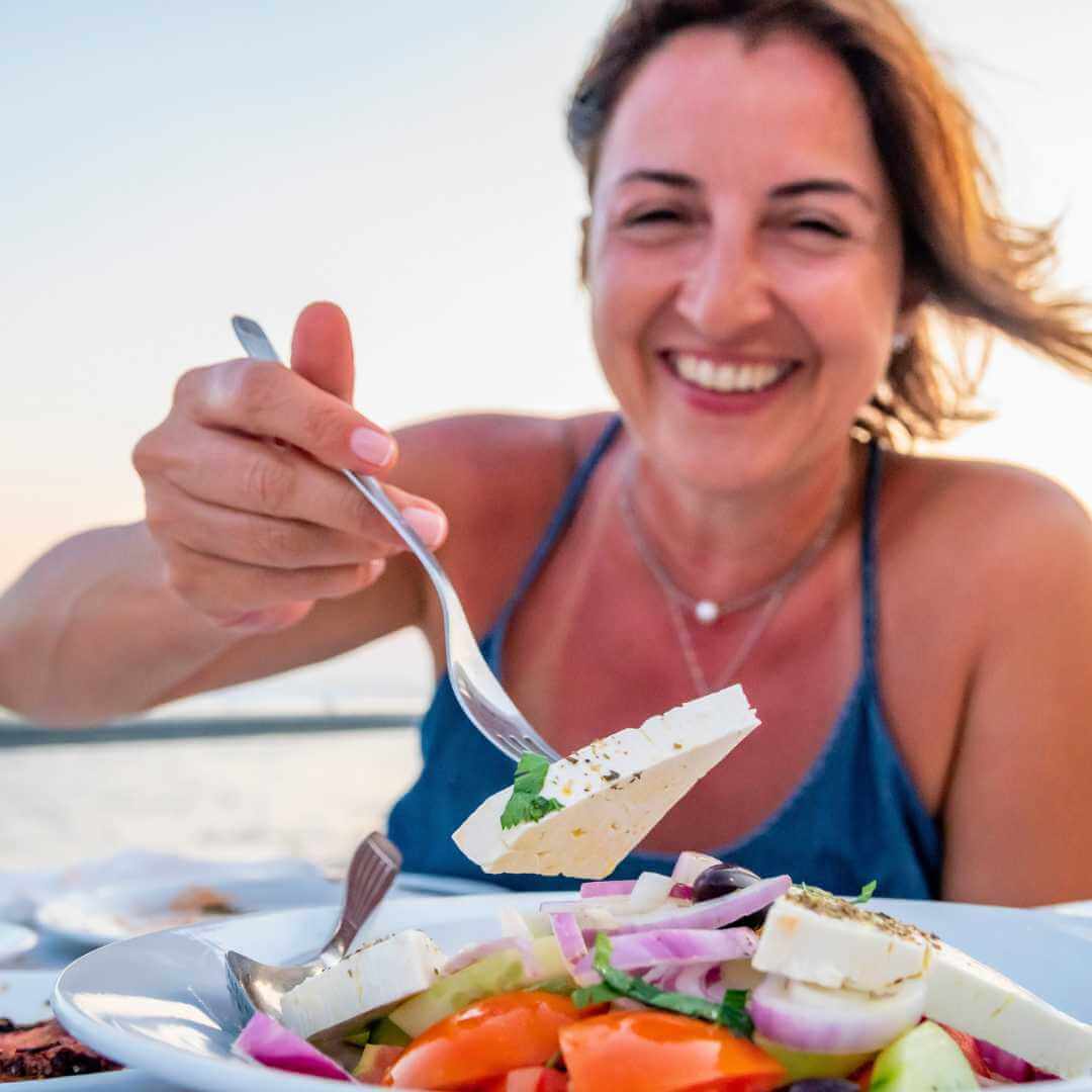 Una gentile donna greca suggerisce di provare il formaggio locale