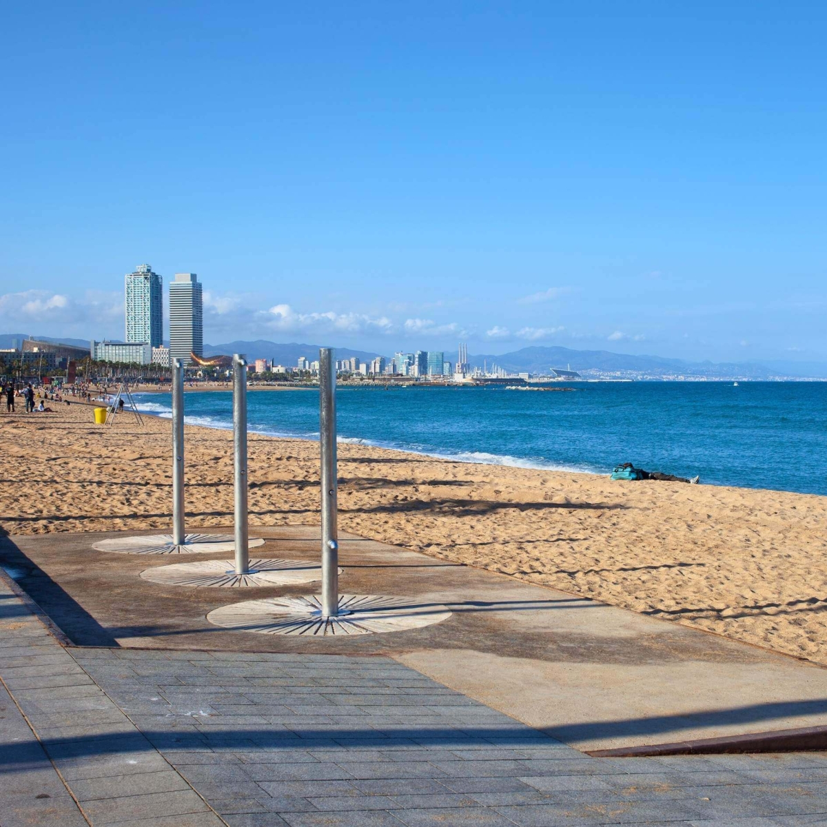 Spiaggia della Barceloneta sul Mar Mediterraneo con docce in una giornata di sole a Barcellona, ​​in Catalogna