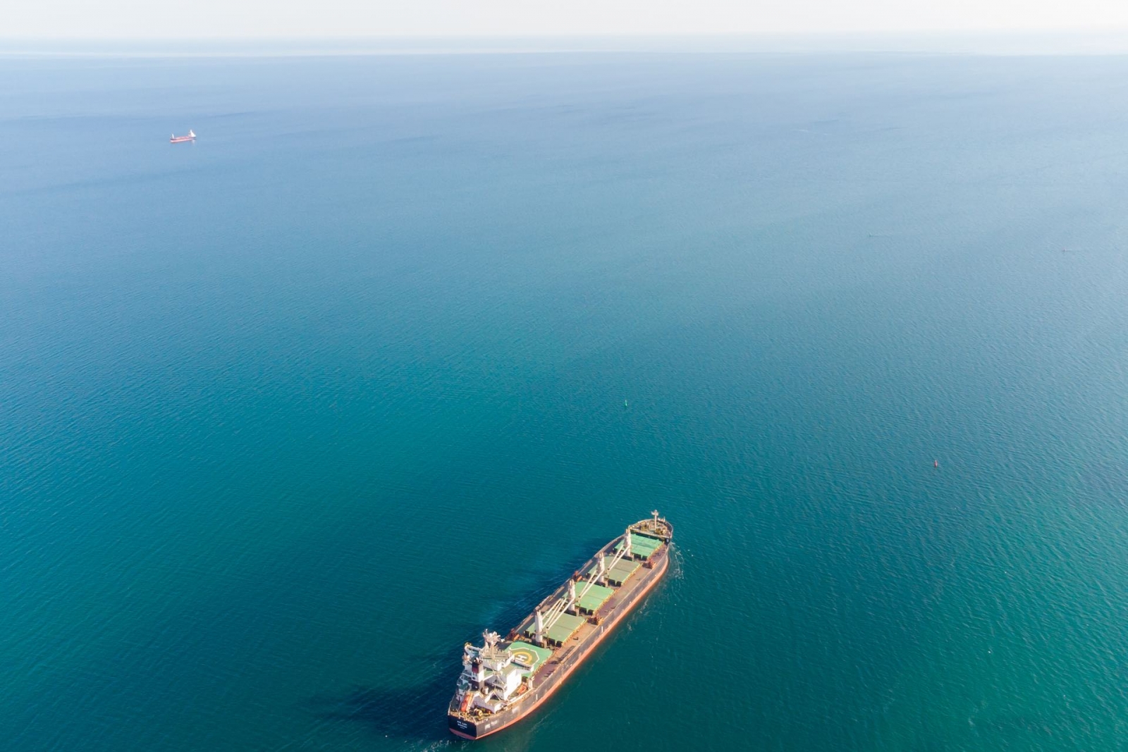 Сухогруз входит в порт с помощью буксиров в Рижском заливе