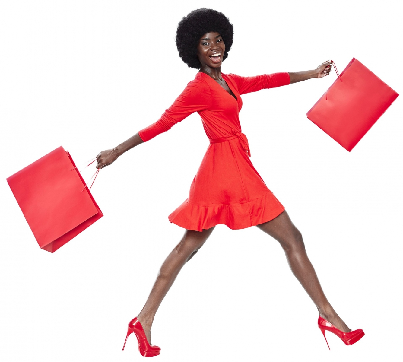 Volle Länge der schönen jungen Afrikanerin im roten Kleid, die rote Einkaufstüten trägt