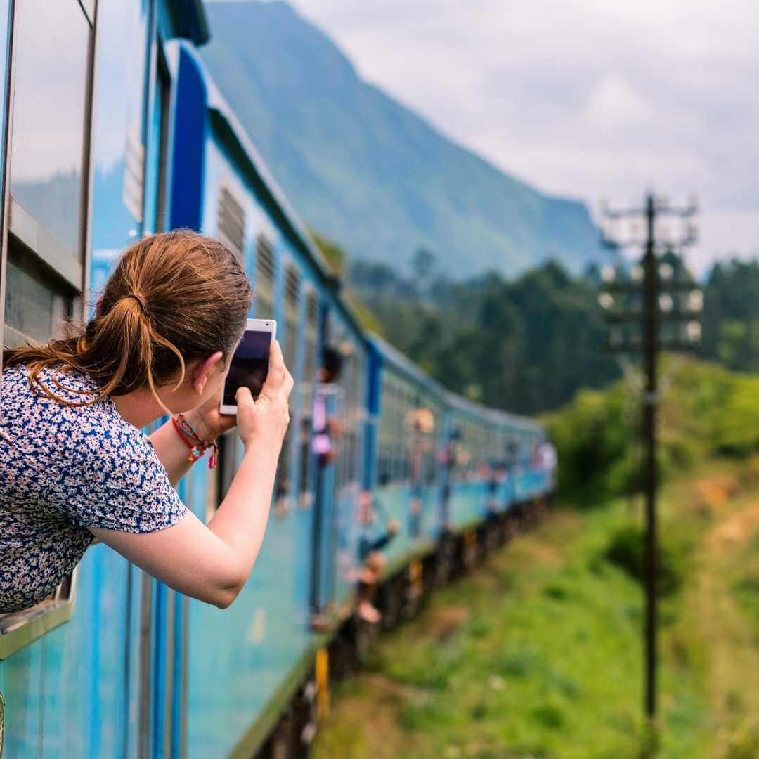 Una giovane donna si scatta una foto direttamente dal finestrino del treno nel viaggio da Ella a Kandy tra le piantagioni di tè negli altopiani dello Sri Lanka (2) 02.13.54