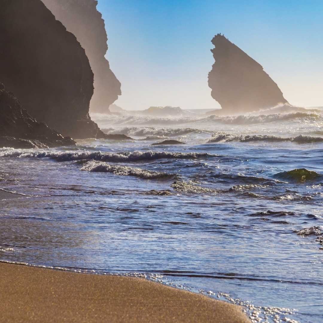 Felsensilhouette, Meereswellen, Strand von Adraga (Praia da Adraga), Portugal