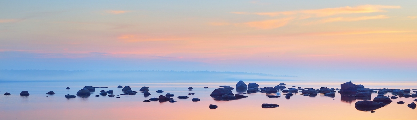 Rocks at the coast of Kasmu (captain's village) at sunset. Estonia, Baltic sea. Clear blue sky, pink clouds. Panoramic view. Travel destinations, vacations, eco tourism