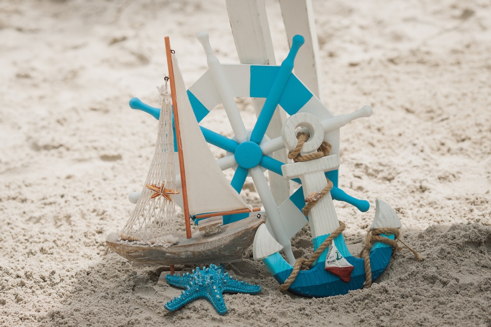 Pequeño barco azul y blanco y ancla en una playa