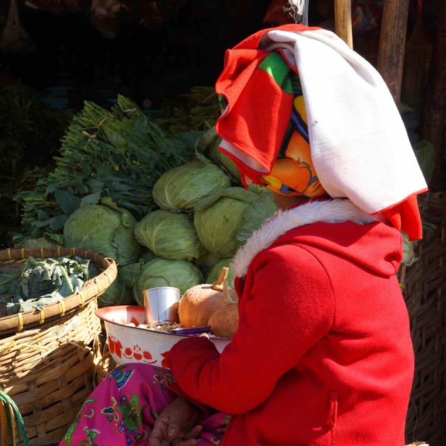 Una donna Shan si prende cura di un chiosco di verdure
