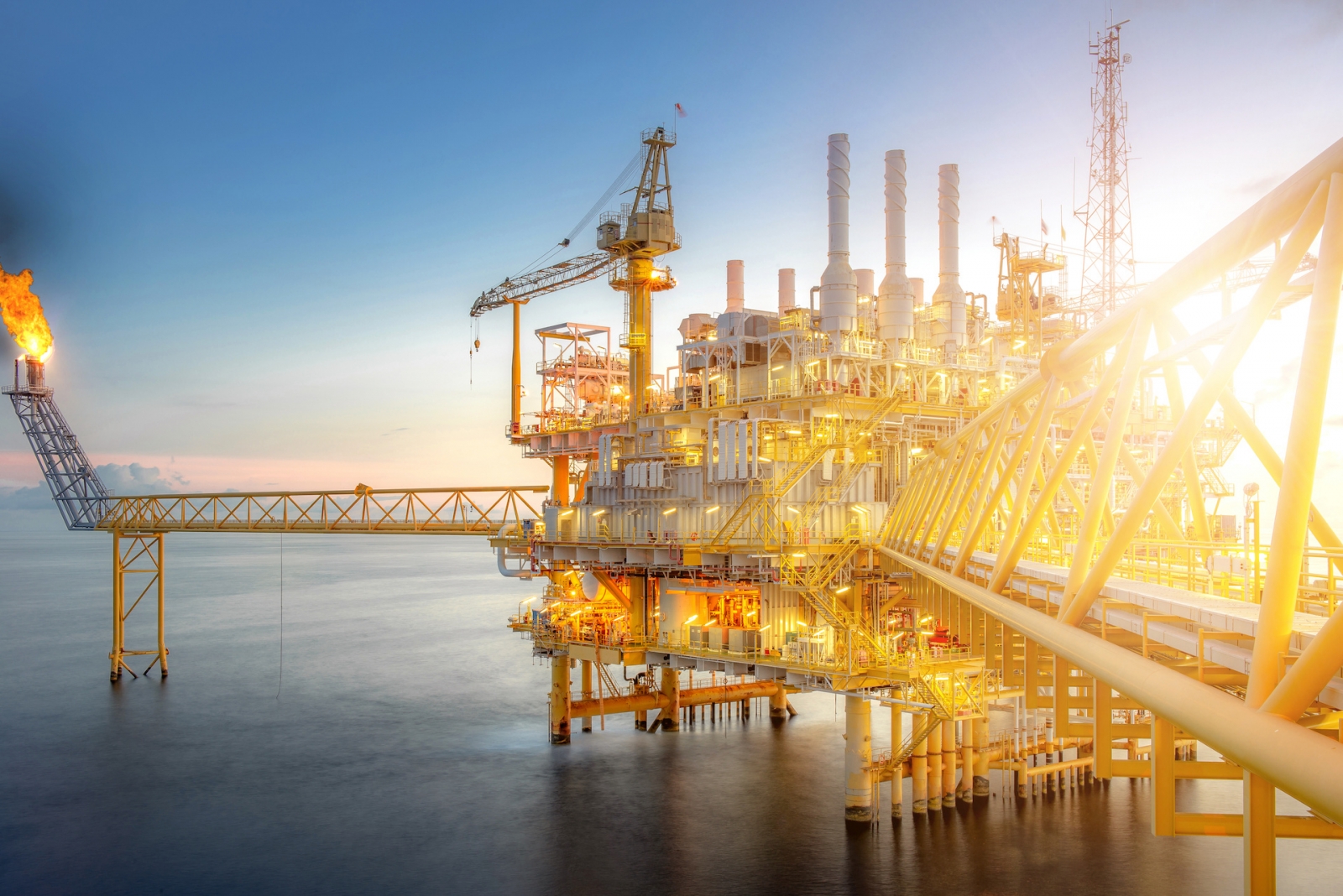 Gran planta de plataforma petrolera de perforación en alta mar en el golfo en el crepúsculo